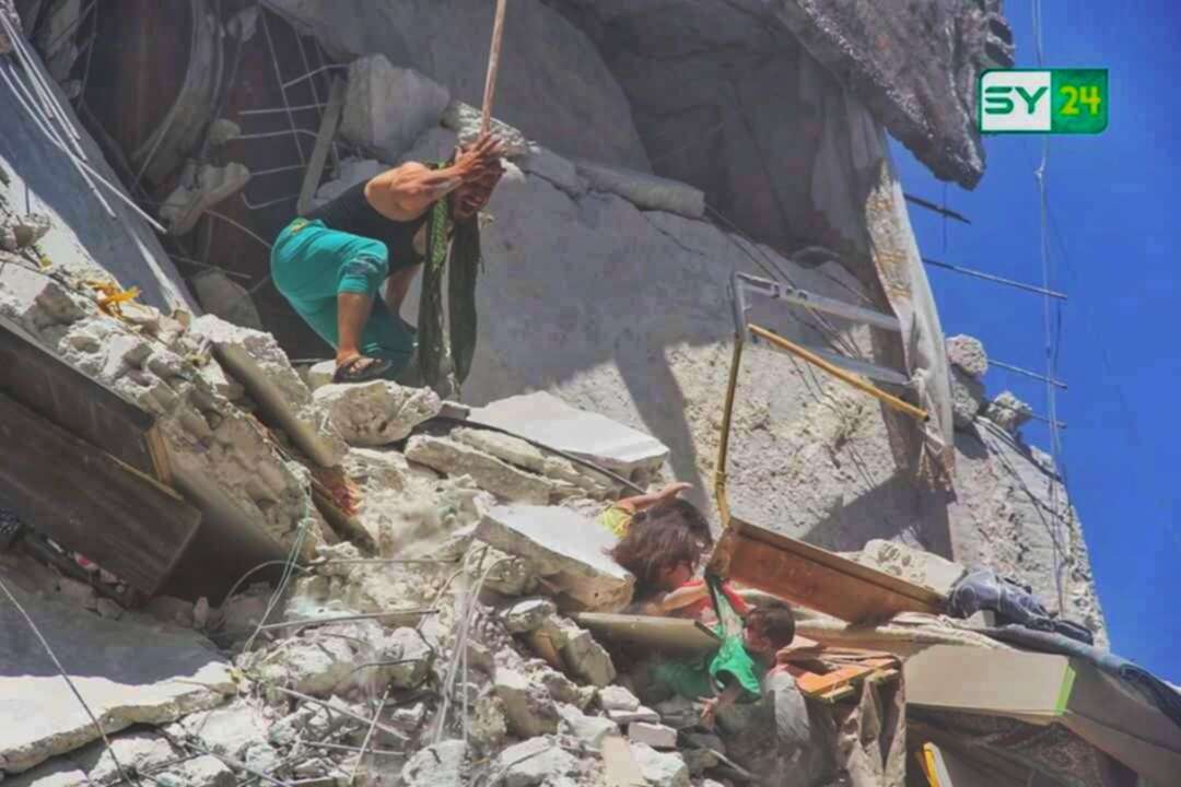 Shocking image from Syria shows girl, 5, clinging to sister's T-shirt at bombed building