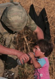In this June 14, 2015, file photo a Turkish soldier offers water to a Syrian refugee child after crossing into Turkey from Syria, in Akcakale, Sanliurfa province, southeastern Turkey. As Turkish forces invaded northern Syria in early October 2019, supporters of the offensive launched an online misinformation campaign. Dozens of misleading images claiming to show Turkey’s soldiers cuddling babies, feeding hungry toddlers and carrying elderly women spread across Twitter and Instagram where they were liked, retweeted and viewed thousands of times. They included this photo, which was, in fact, shot by an Associated Press photographer in 2015. (AP)