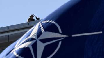A military personnel stands guard on top of the roof during the NATO Summit ceremony at the NATO headquarters. (File photo: AFP)