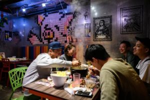 A group of friends share a laugh as they eat together at 66 Hotpot, a family-run restaurant in the bustling district of Mongkok in Hong Kong. (AFP)