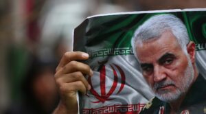 An Iranian holds a picture of late General Qassem Soleimani, head of the elite Quds Force, who was killed in an air strike at Baghdad airport, as people gather to mourn him in Tehran, Iran January 4, 2020. (Reuters)