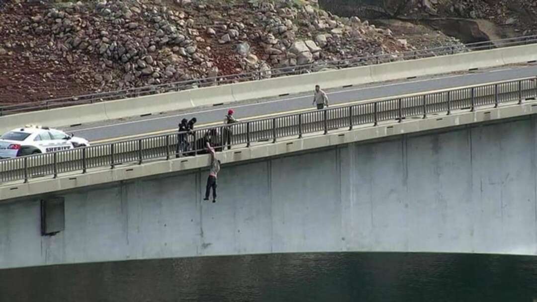شرطي ينقذ رجلاً كان يحاول أن يرمي نفسه من جسر مرتفع