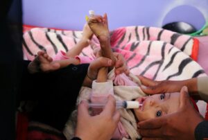 A man holds a malnourished girl as a woman feeds her at the malnutrition department of the al-Sabeen Maternity and Child Hospital in Sanaa. (File photo: Reuters)