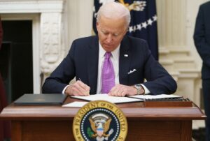 US President Joe Biden signs executive orders as part of the Covid-19 response in the State Dining Room of the White House, Jan. 21, 2021. (AFP)