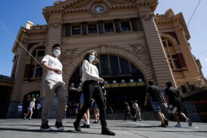 People cross a street in Melbourne on February 12, 2021, after authorities ordered a five-day state-wide lockdown starting at midnight local time to stamp out a new coronavirus outbreak. (AFP)