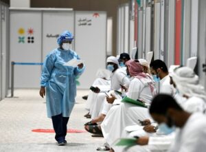 People sit as they wait their turn for vaccine trials in Abu Dhabi, UAE, October 6, 2020. (Reuters)