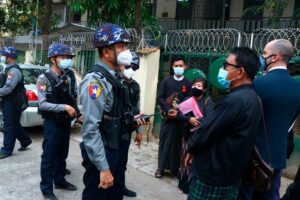 Myanmar police talk to people gathering outside the Kamayut court in Yangon, Myanmar Friday, March 12, 2021. (AP)