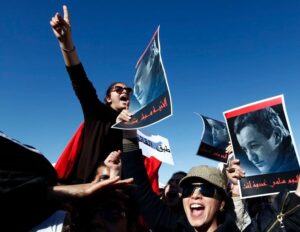 Tunisian protesters hold posters depicting Sami Fehri, TV producer and director of Ettounsiya Television, during a demonstration outside Mornaguia jail calling for the liberation of Fehri, in Tunis December 24, 2012. (Reuters)