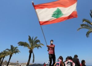 A demonstrator waves a national flag during a protest in Tyre, Lebanon. (File photo: Reuters)
