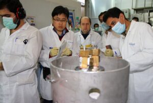 Unidentified International Atomic Energy Agency (IAEA) inspectors (2nd-3rd L) and Iranian technicians disconnect the connections between the twin cascades for 20 percent uranium production at nuclear research centre of Natanz, some 300 kilometres south of Tehran on January, 20, 2014. (AFP)