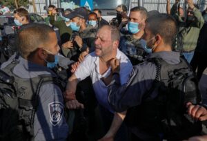 Israeli policemen detain Israeli MP Ofer Cassif, a Jewish member of the predominantly Arab Joint List electoral alliance. (AFP)