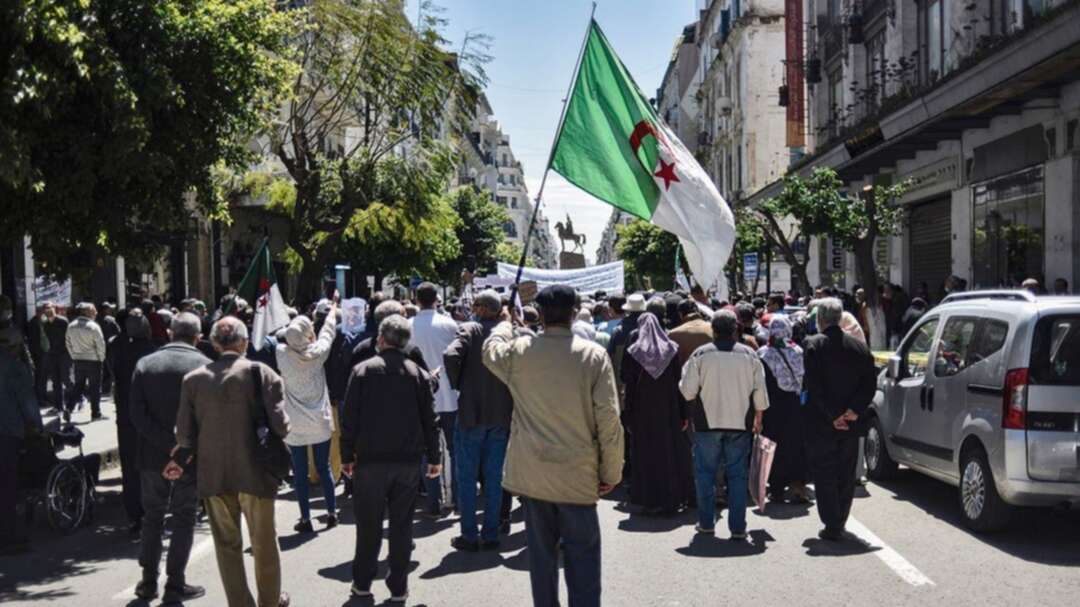 People chant slogans as they march during a student-led anti-government demonstration in Algeria's capital Algiers on April 20, 2021. (Ryad Kramdi/AFP)
