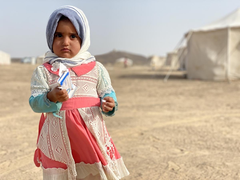 فتاة يمنية تبلغ من العمر عامين نزحت بسبب النزاع في الجوف ، تقف خارج مأواها في موقع استضافة النازحين في مأرب