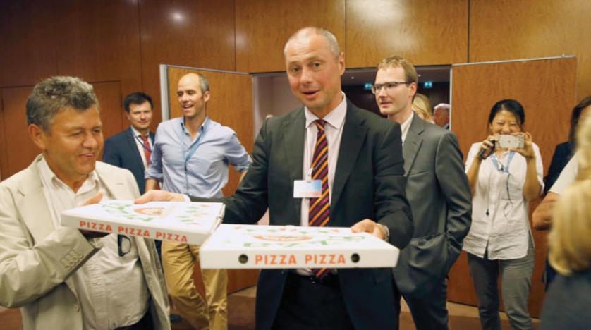 ألكسندر زورين الضابط الروسي يوزع البيتزا على صحافيين في جنيف سبتمبر 2016 ( أ.ف.ب)